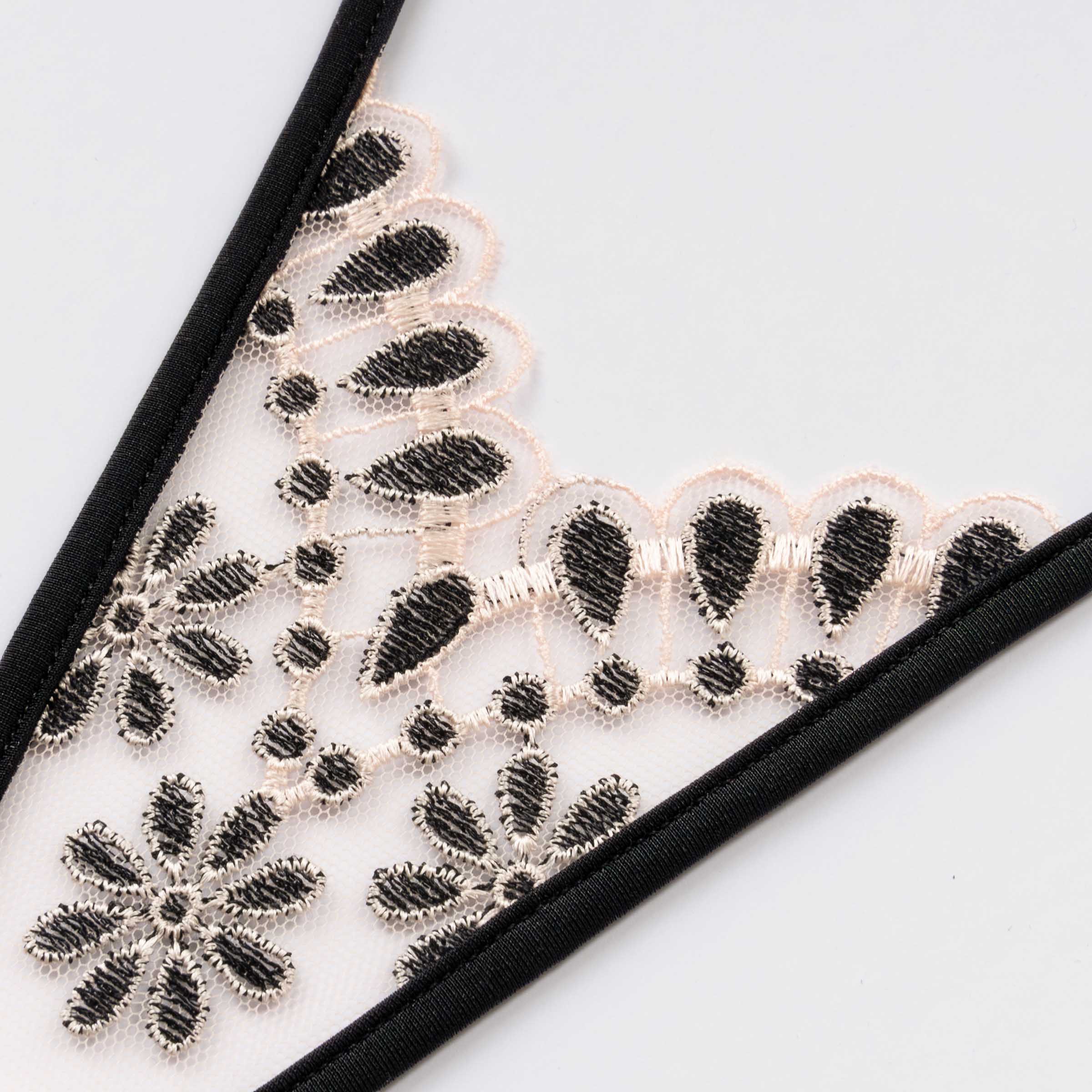 Micro T-String aus zartrosa Tüll bestickt mit einem floralen Muster in Schwarz und Rosa